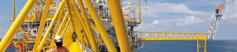 A worker walking on a platform of an offshore rig. 