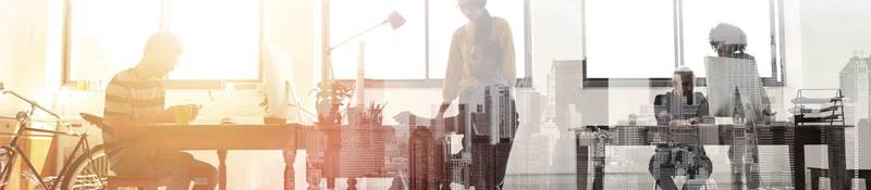 People collaborating in an office/agency setting with the backdrop of a city. 