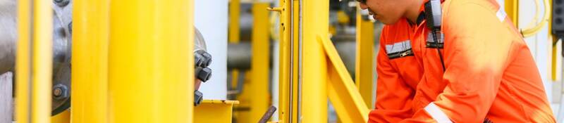 Oil rig worker checking gauge