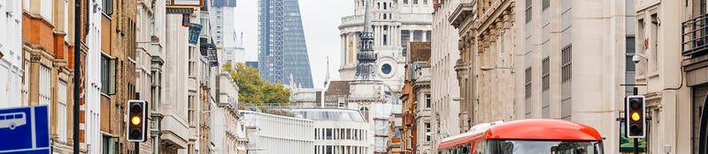 People walking on a busy street in London, England near St. Paul's Cathedral.