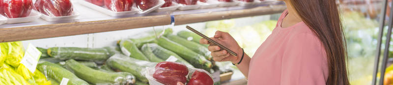 Customer in a grocery store scanning a QR code