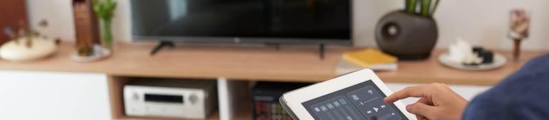 Woman controlling a smart home system with a tablet 