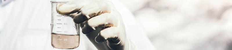 Person wearing protective gear testing water sample