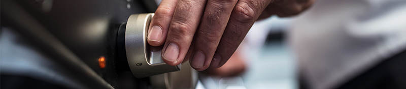 A hand adjusting the dial on a kitchen stove