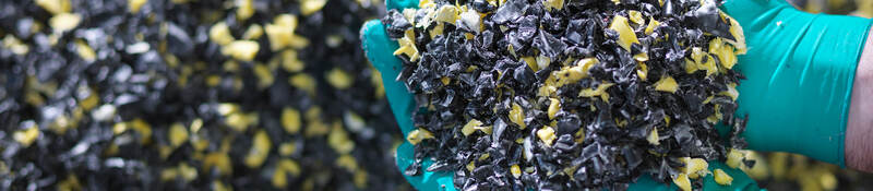 Worker holding recycled plastic in plastics factory