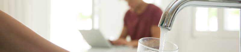 Man sitting at computer, faucet running