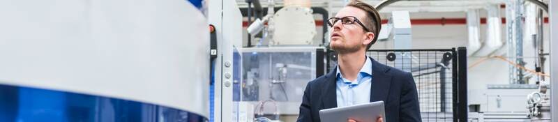 man on tablet looking at machine