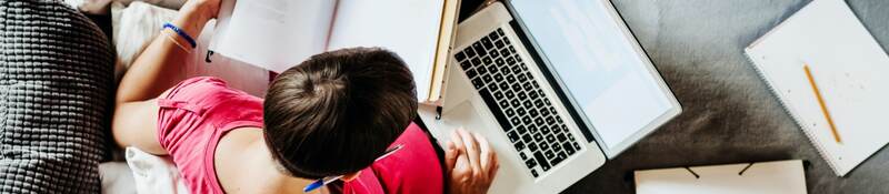 overhead shot of woman working on computer on her couch