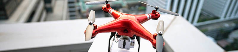 Red drone flying in the city