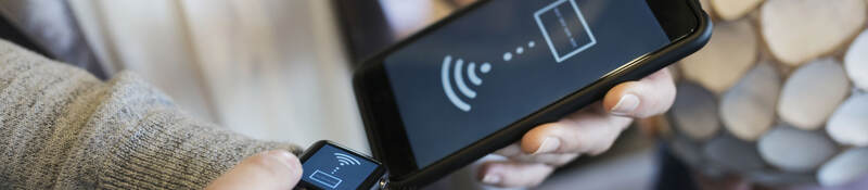 A person pairing up a cellphone and smart watch