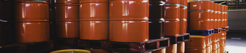Stacks of red oil barrels in a warehouse