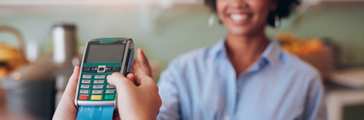 Woman paying for a retail transaction with EMV technology.