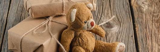 Brown toy bear on a wooden rustic table.