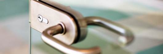 an abstract detail of a contemporary door handle for a glass door