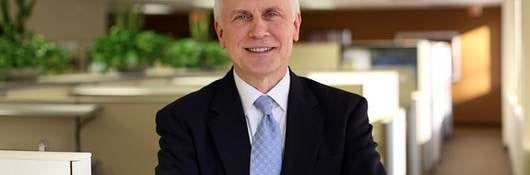 Bruce Bailey standing with arms crossed in office setting