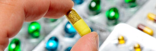 Close-up of hand holding a pill