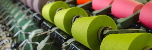 Textile industry - yarn spools on spinning machine in a textile factory