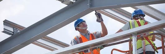 A construction worker laboring on a steel structure