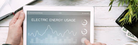 Man holds tablet PC with electric energy usage application