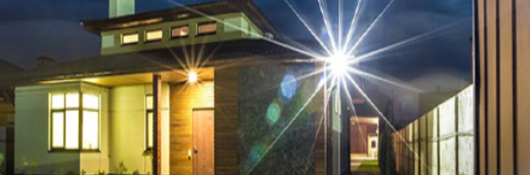 Outside view of modern home in evening with bright light shining outward