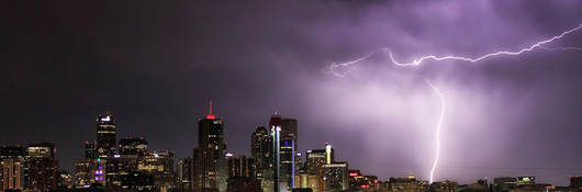 Nighttime skyline with lightning striking a building