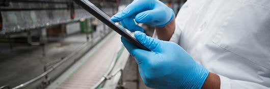 A worker checks a tablet computer.  