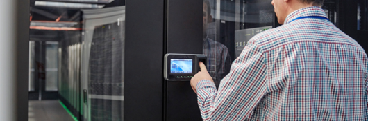 Man entering code on keypad at a room full of servers