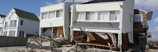 A white clad destroyed beach house four months after Hurricane Sandy.