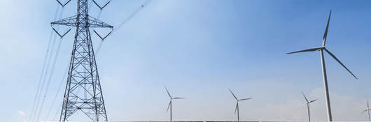 Power line, solar panels and wind turbines against blue sky