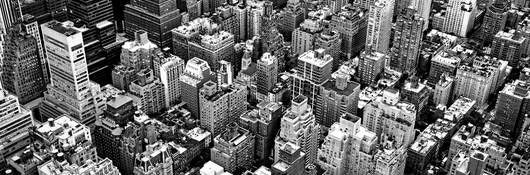 A black and white photo of the densely packed New York City landscape.