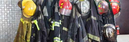 Firefighter gear hangs in a row, waiting for the next call