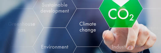 Man in suit jacket touching a CO2 icon with his fingertip to indicate embodied carbon.