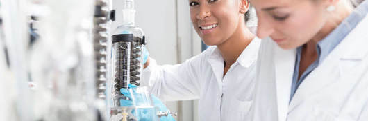 Group of scientists working with gloves and gowns in laboratory.