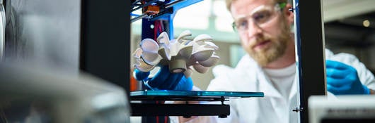 Photo of a scientist testing 3D printed plastic object