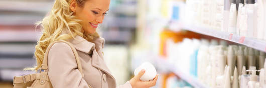 Woman looking at personal care bottles in a retail store