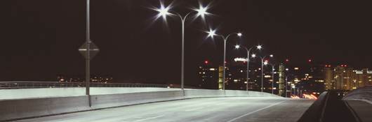 Streetlights at night on quiet road. 