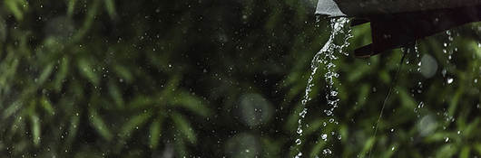photo of rain draining off a tin roof
