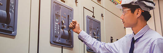 An engineer is checking voltage or current by voltmeter in control panel of power plant