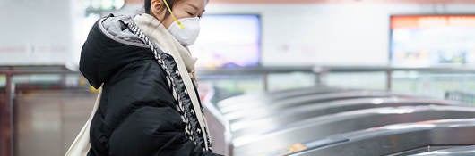 Woman wearing a mask paying to use the subway