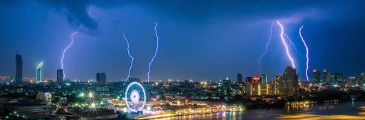 lightning striking cityscape at night 