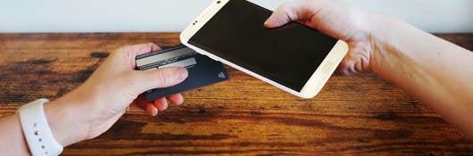 chip-enabled credit card in touching a cellphone