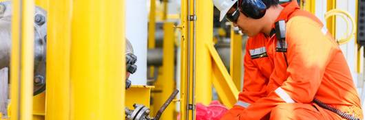 Oil rig worker checking gauge