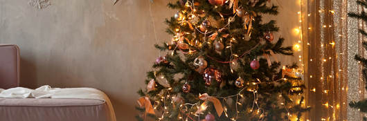 A living room with pre-lit Christmas tree and other lit decorations
