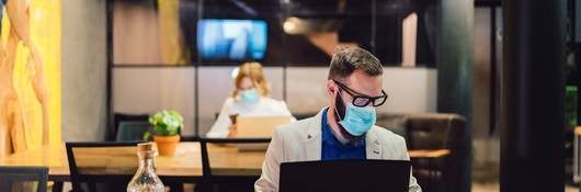 Workers in commercial real estate building wearing proper personal protective equipment and following safety guidelines 