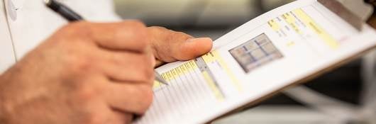 person marking on a clipboard