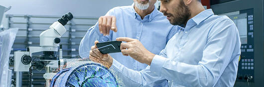 two male laboratory technicians observing a digital model