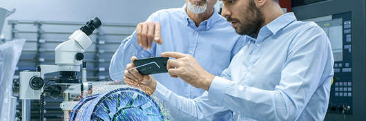 two male laboratory technicians observing a digital model