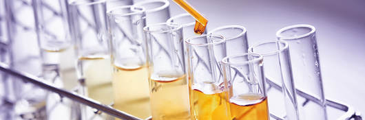 Test tubes and pipette containing an orange liquid