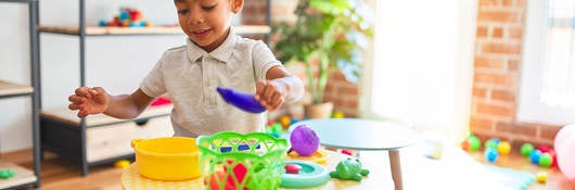 Child playing with plastic food and cutlery toys