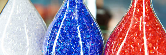 Colorful plastic granular polymer in glass flasks